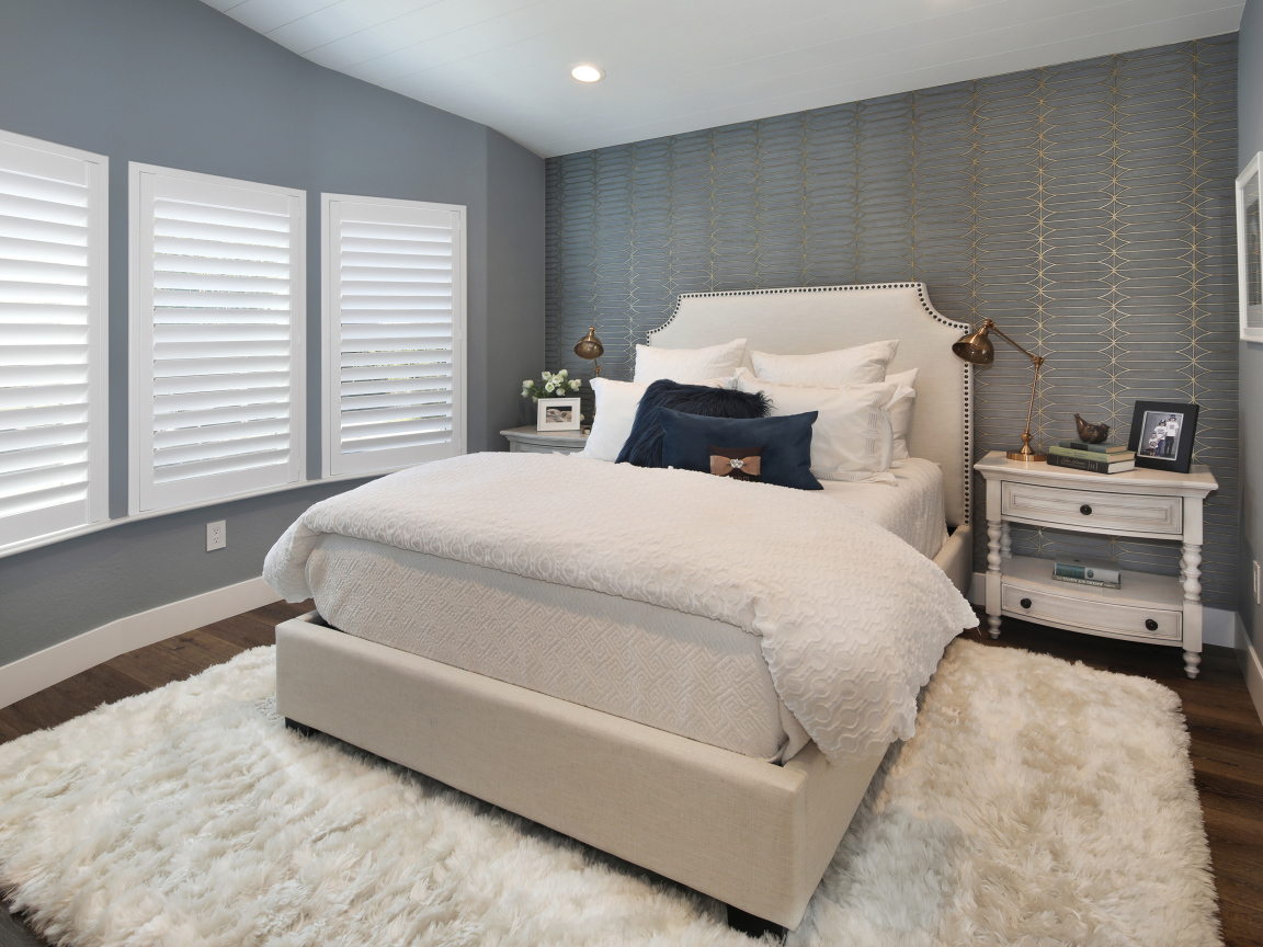 Высокая кровать в спальной комнате в серых тонах