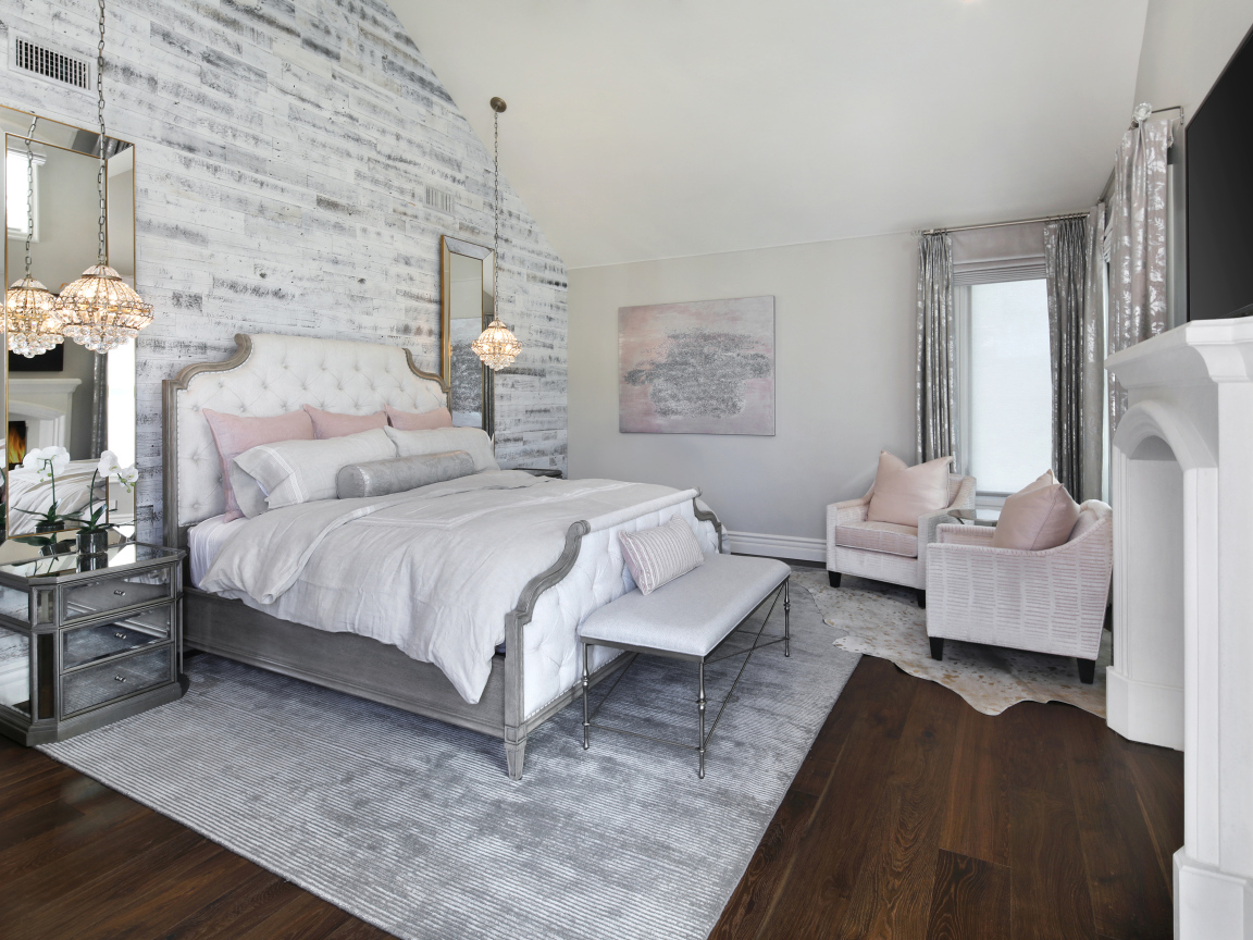 Большая кровать в светлой спальне  с камином