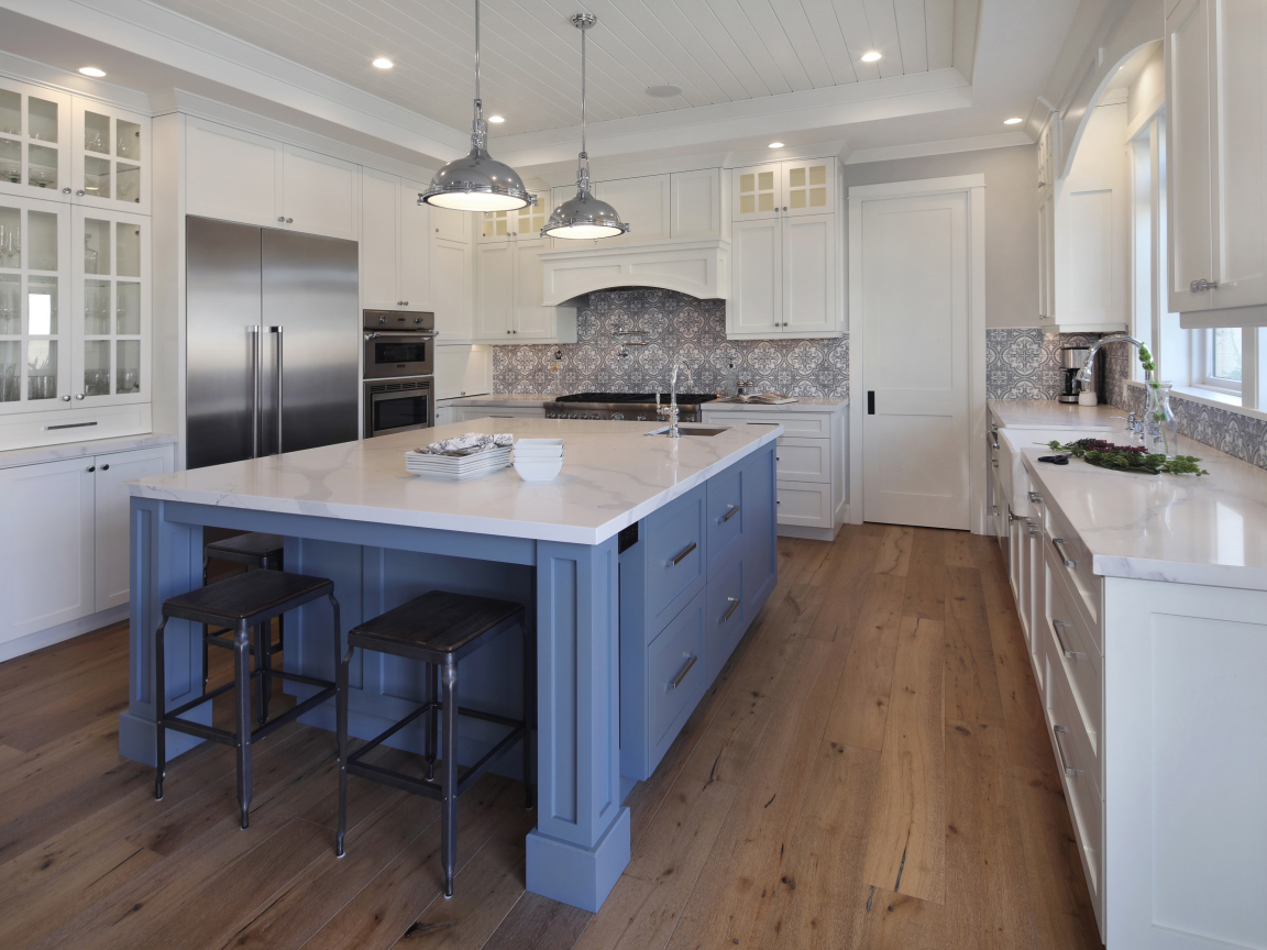 Большой серый стол в просторной белой кухне 