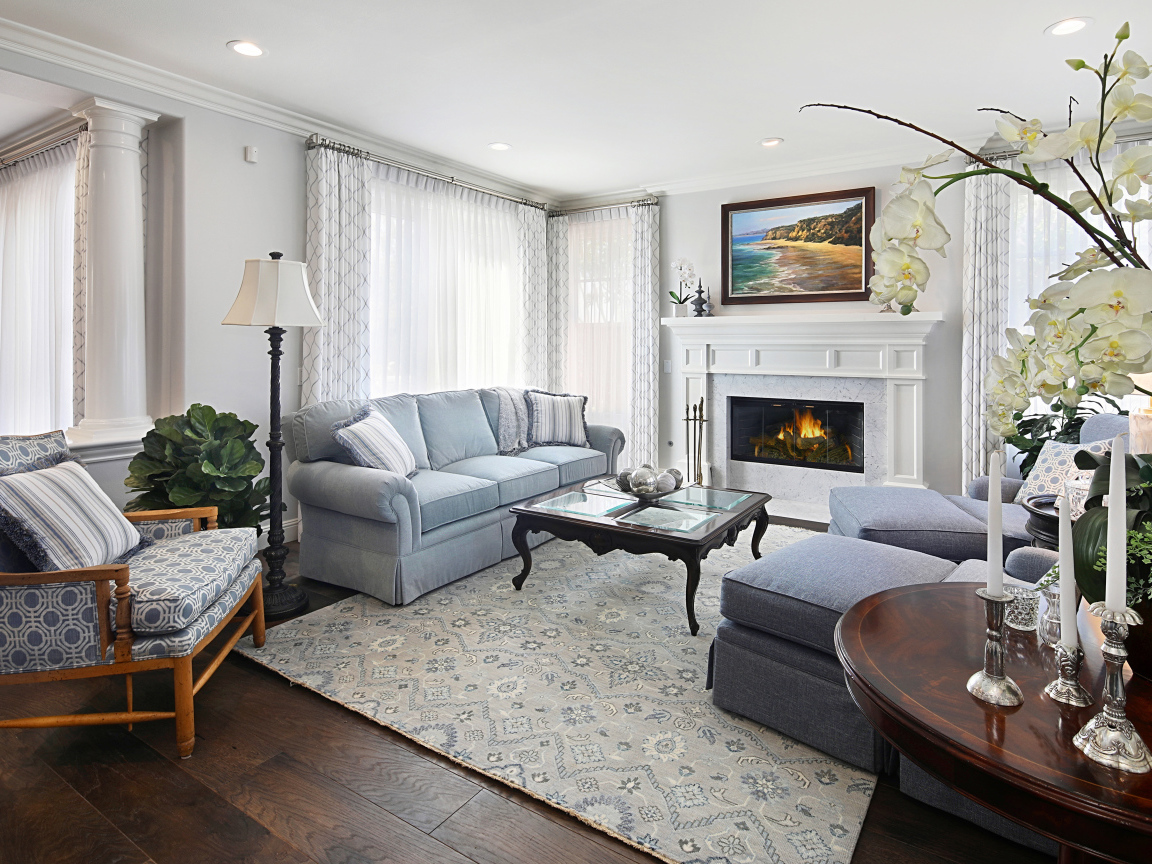 Большая гостиная комната с камином и живыми цветами