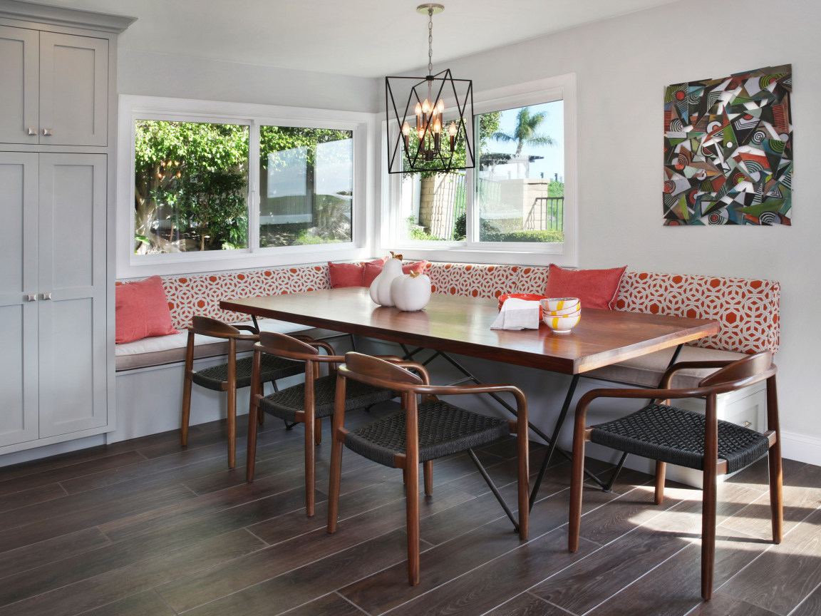 Большой деревянный стол и диван у окна в гостиной 