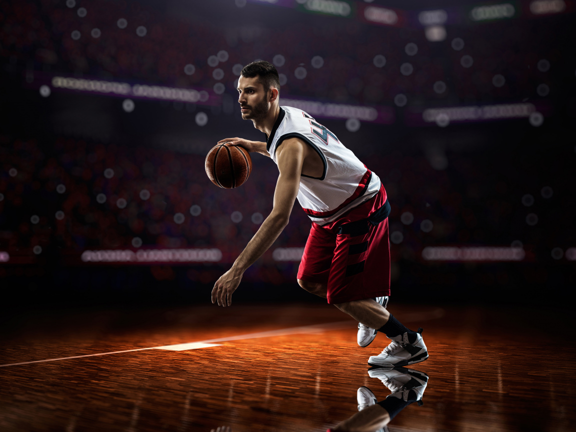 Мужчина баскетболист отбивает мяч на поле 