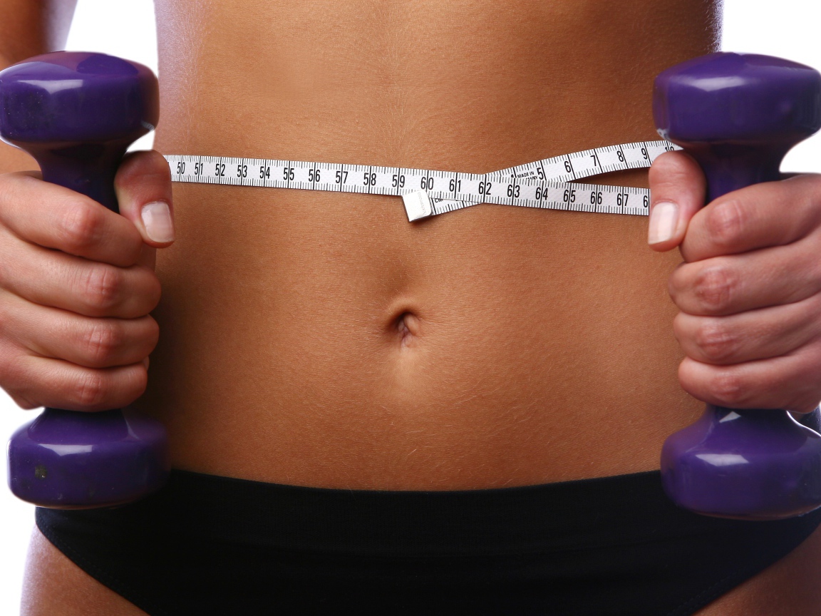 Стройная спортивная девушка с гантелями в руках 