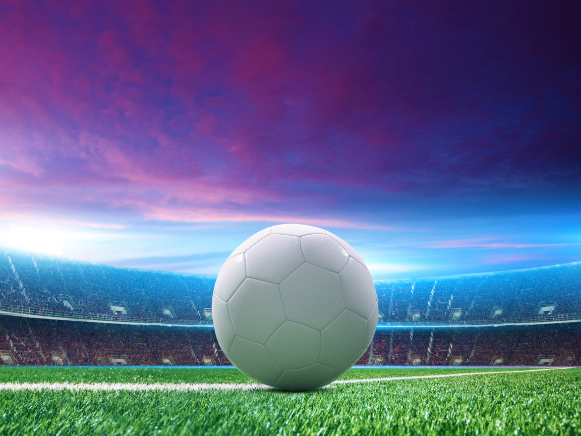 Белый футбольный мяч на зеленой траве на стадионе 