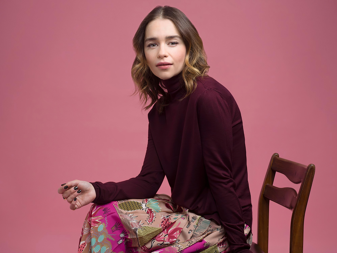 Молодая актриса Эмилия Кларк сидит на стуле