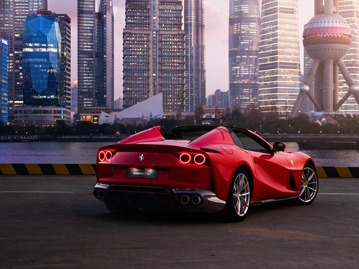 Автомобиль  Ferrari 812 GTS вид сзади на фоне города