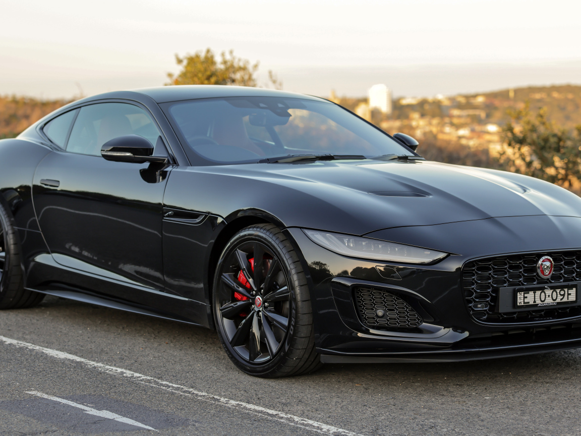 Дорогой черный автомобиль Jaguar F-Type R на дороге