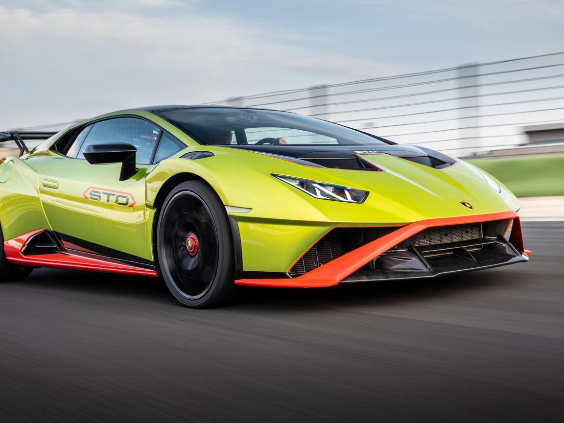Зеленый автомобиль Lamborghini Huracán STO 2021 года на высокой скорости 