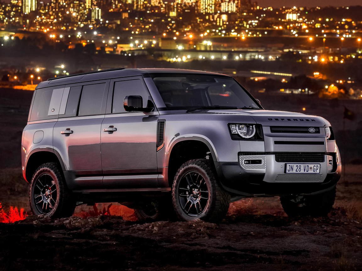 Серебристый внедорожник Land Rover Defender 110 P400 S Urban Pack 2021 года на фоне города