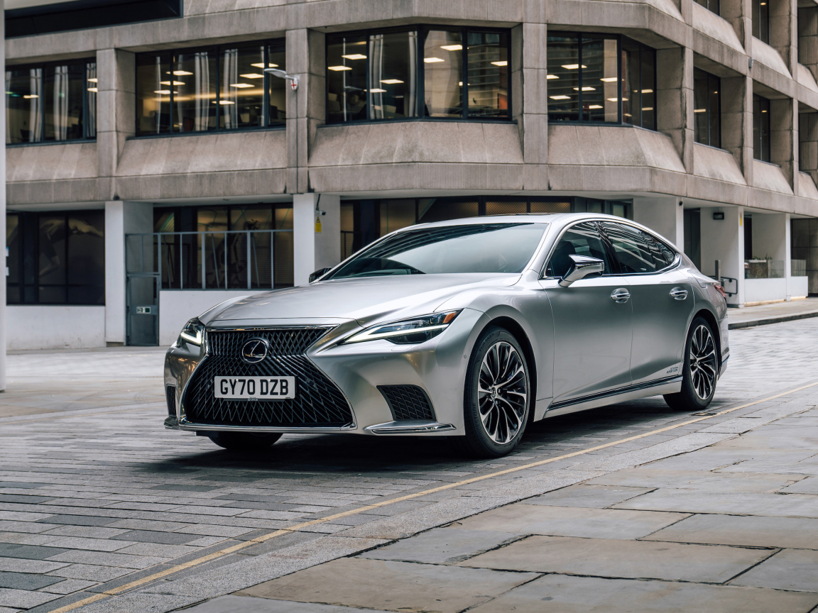 Серебристый автомобиль Lexus LS 500h 2021 года в городе у дома