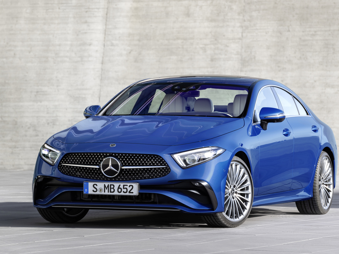 Синий автомобиль Mercedes-Benz CLS 350 AMG Line 2021 года на фоне серой стены