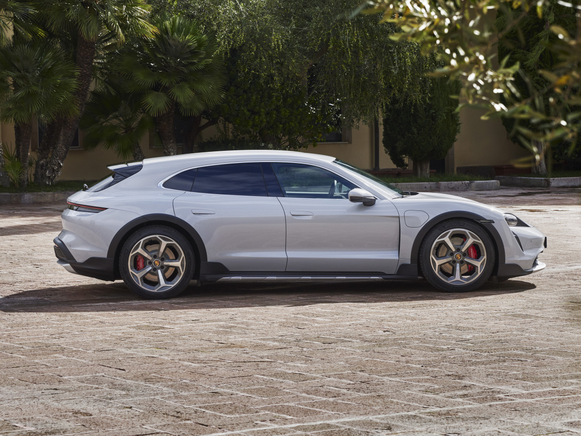 Серебристый автомобиль Porsche Taycan 4S Cross Turismo 2021 года у дома
