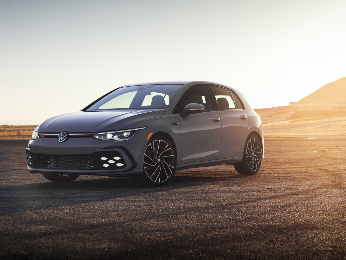 Серебристый автомобиль Volkswagen Golf GTI на фоне заката