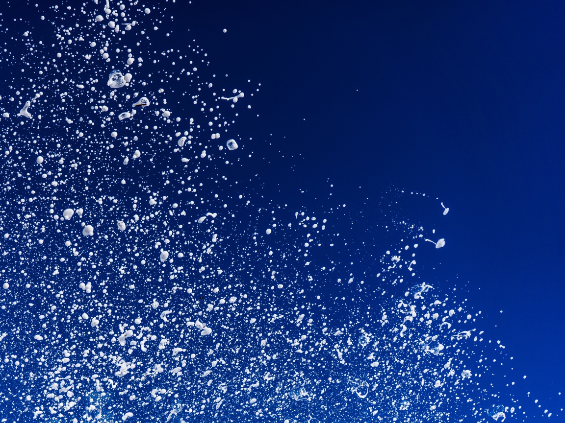 Белые брызги воды на синем фоне 