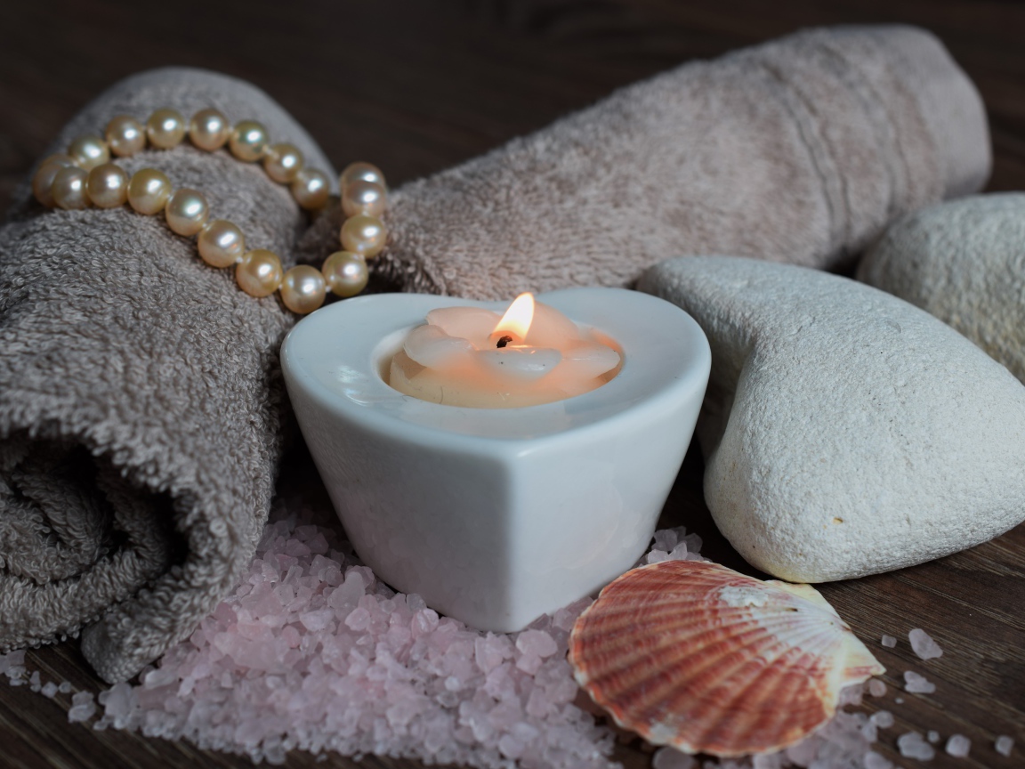 Красивая свеча с полотенцем, бусами, камнями и морской солью