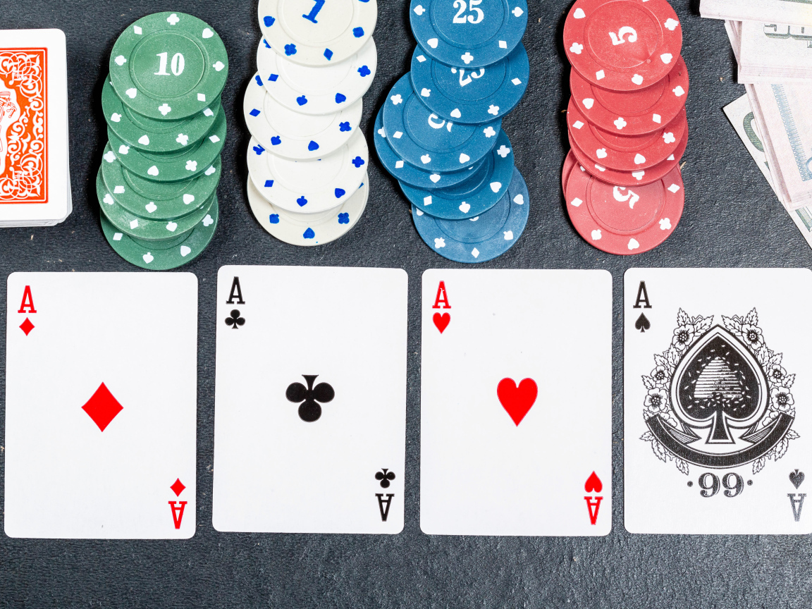 Четыре туза с фишками на сером столе