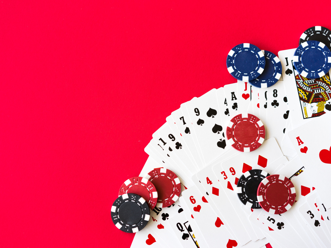 Карты для покера и фишки на красном фоне 