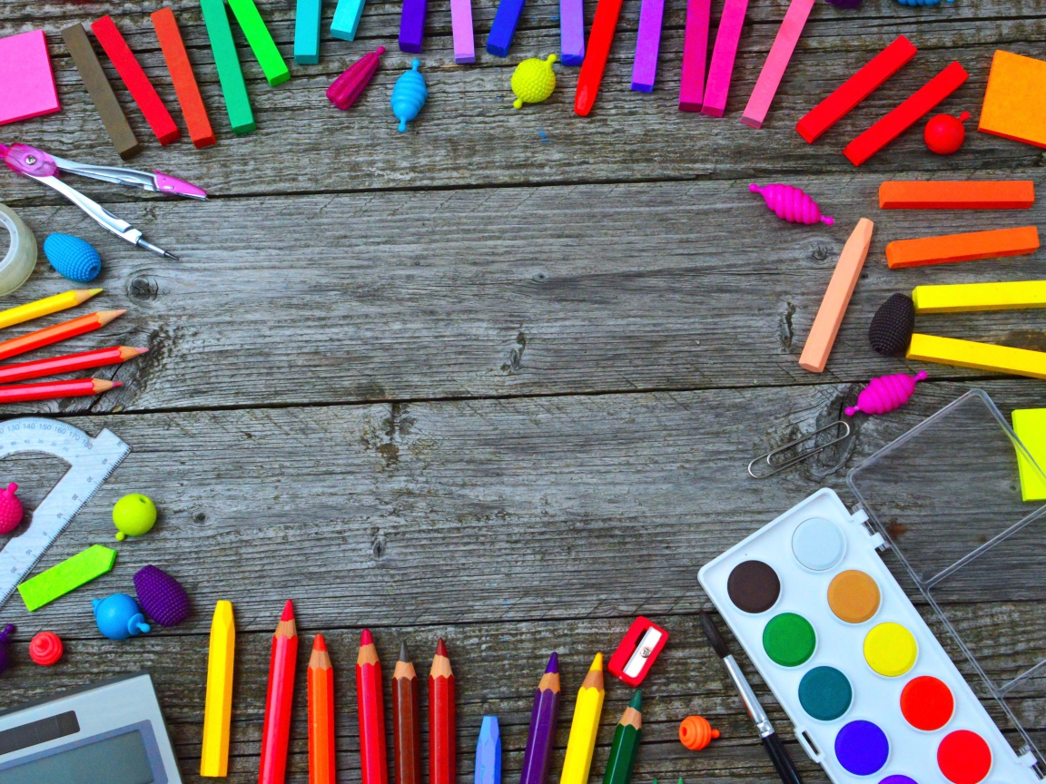 Радуга ярких канцелярских предметов для школы  на деревянном столе