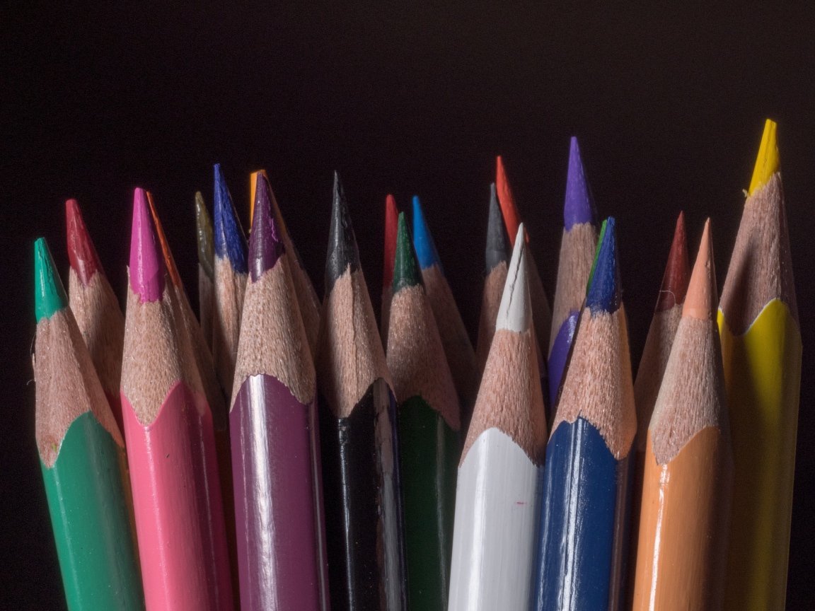 Острые разноцветные карандаши для рисования на черном фоне