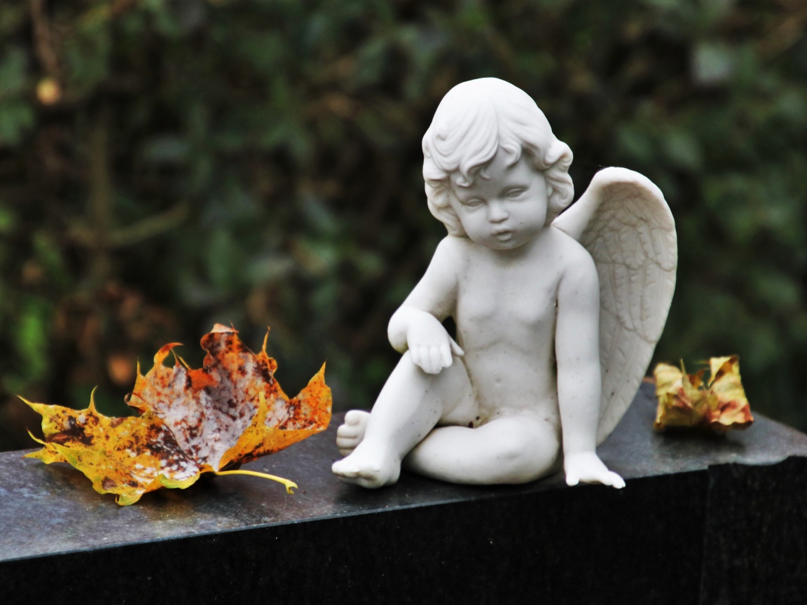 Статуэтка белого ангела с желтыми листьями
