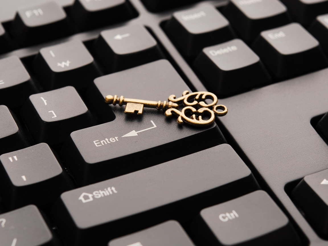 Золотой ключ лежит на черной клавиатуре