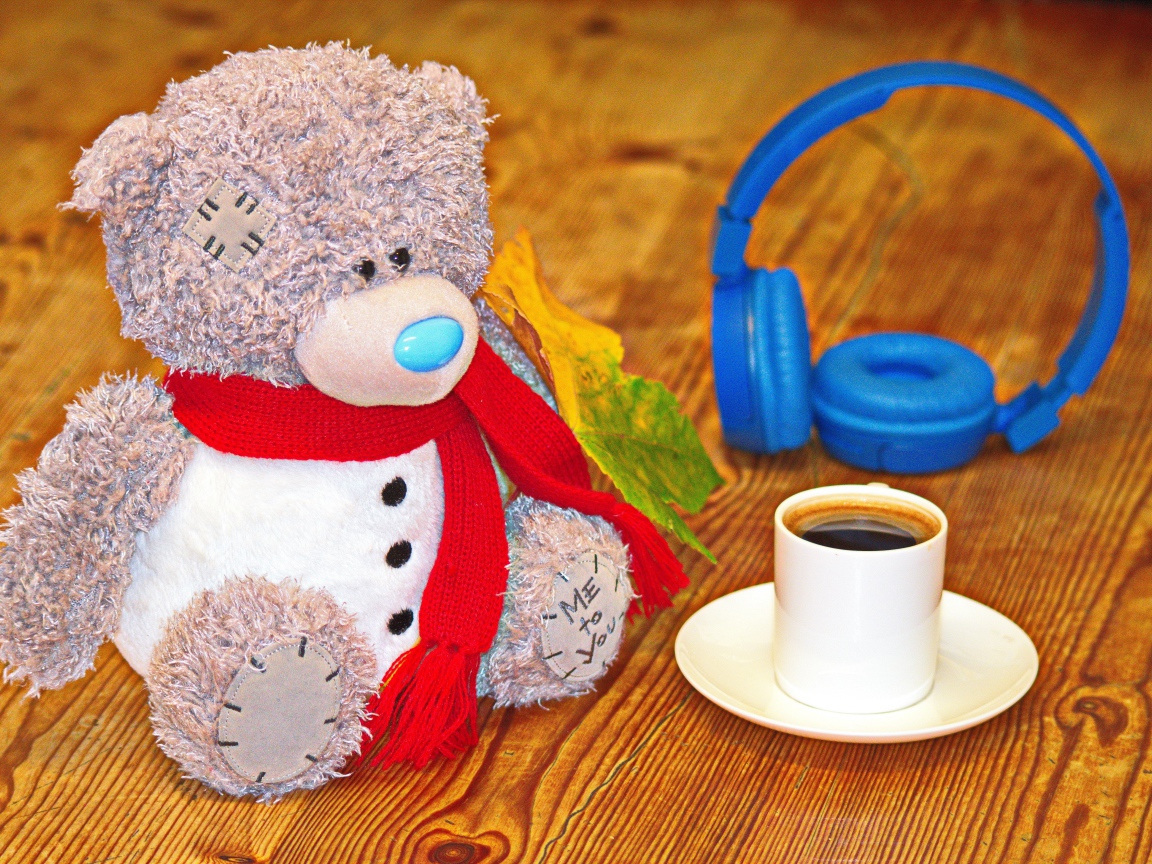 Игрушечный медведь с наушниками и чашкой кофе