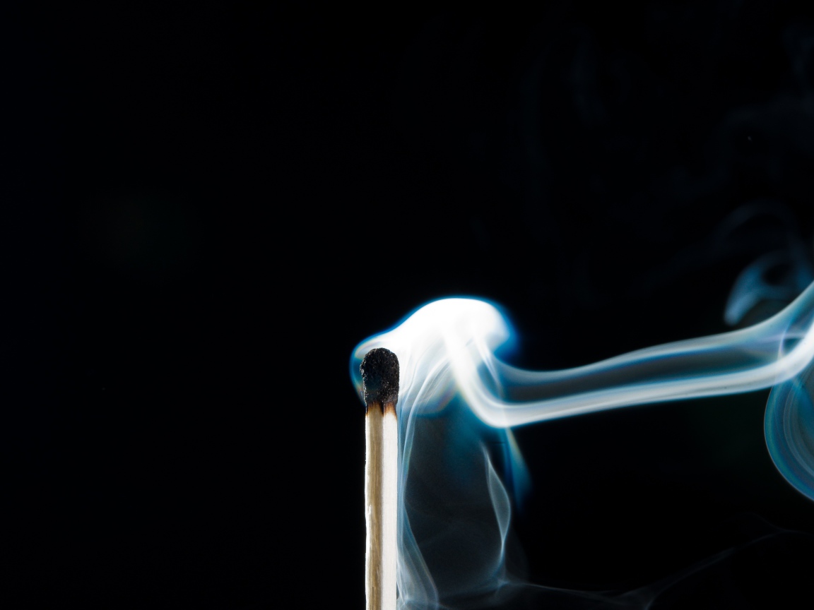 Белый дым от сожженной спички на черном фоне