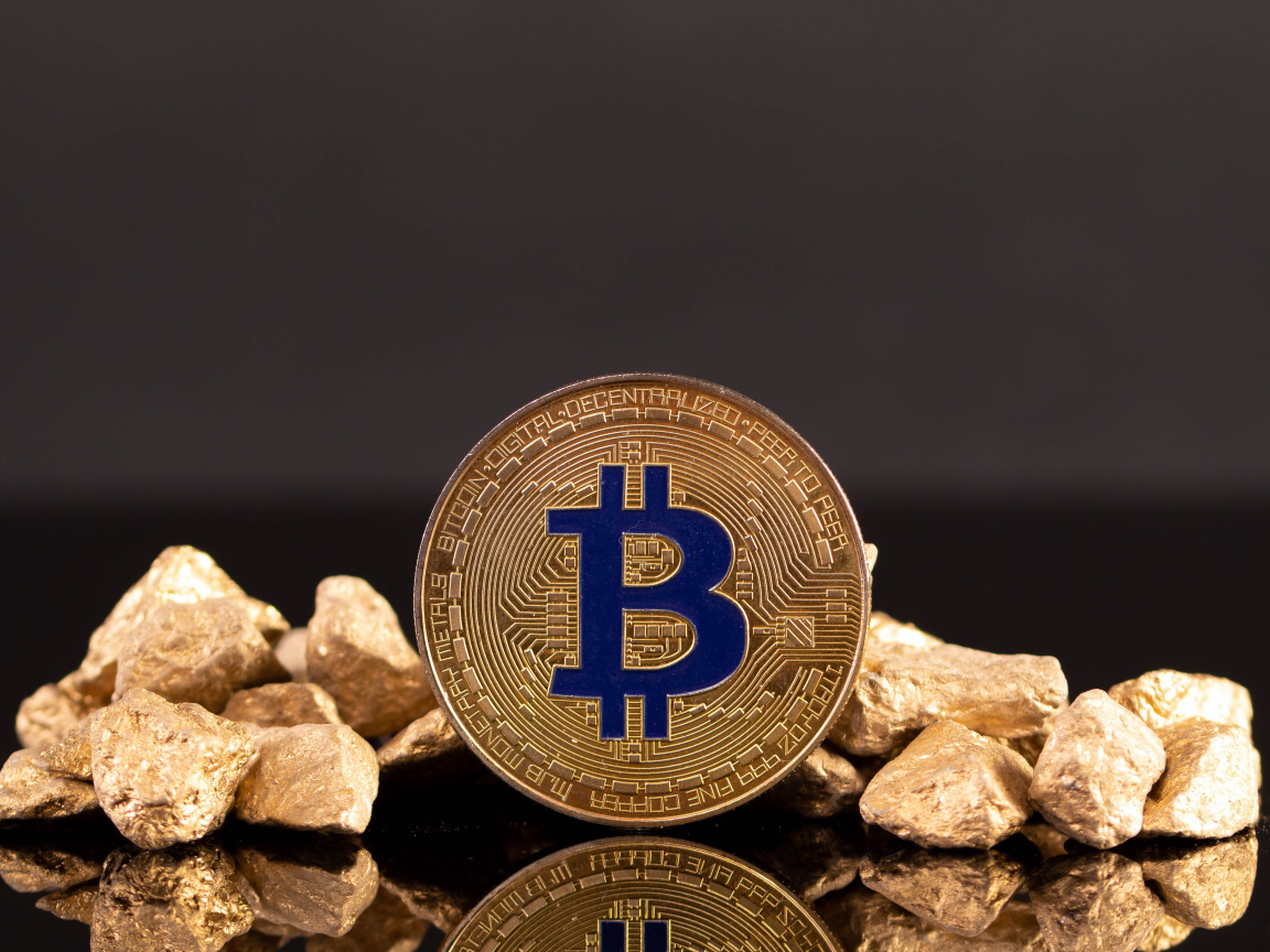 Монета биткоин с кусками золота на сером фоне