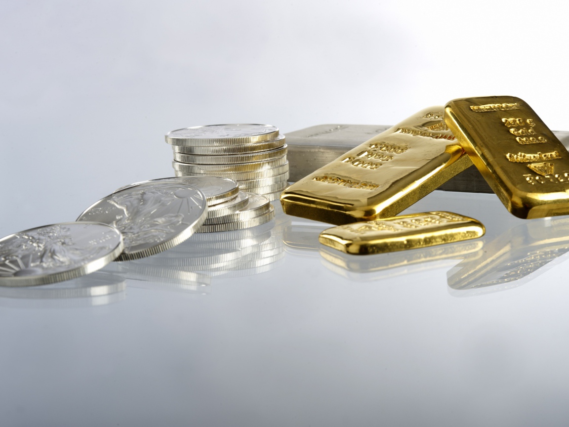 Золотые слитки золота и монеты на белом фоне