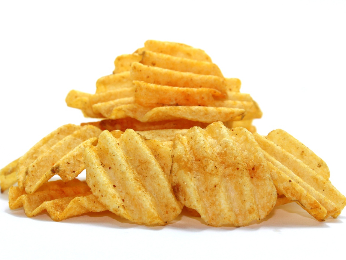 Аппетитные картофельные чипсы на сером фоне