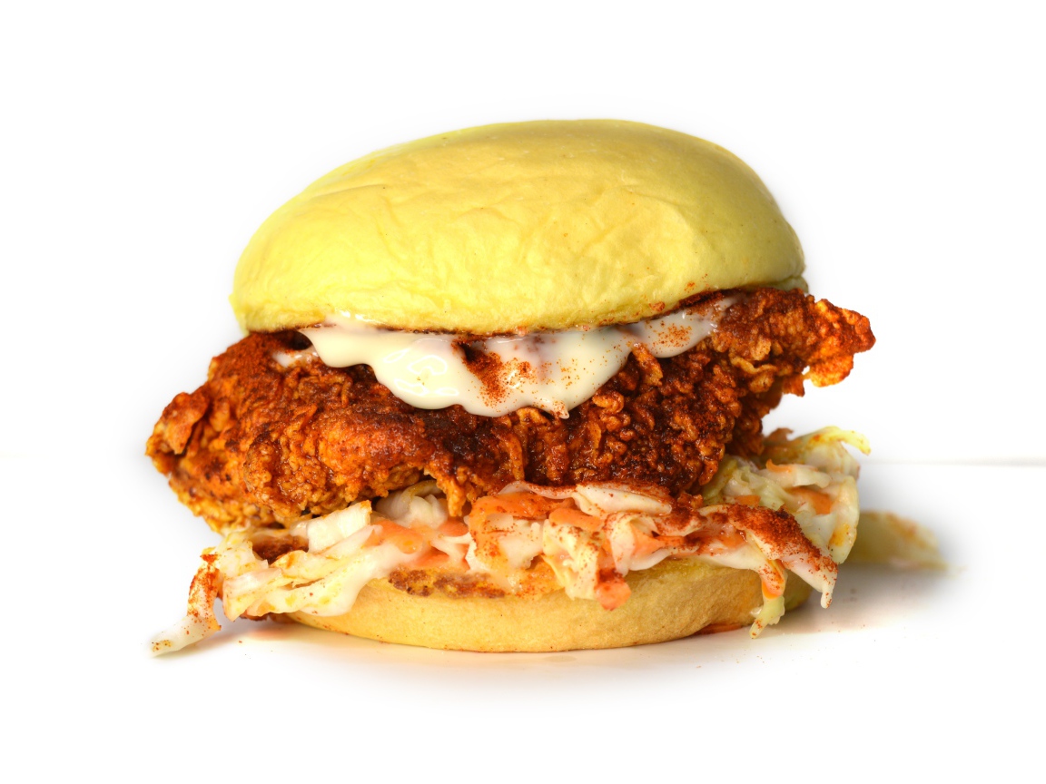 Большой куриный бургер с соусом на белом фоне