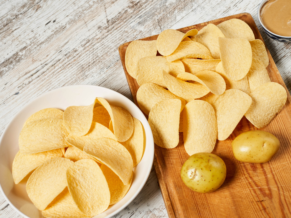 Чипсы на столе с картофелем 