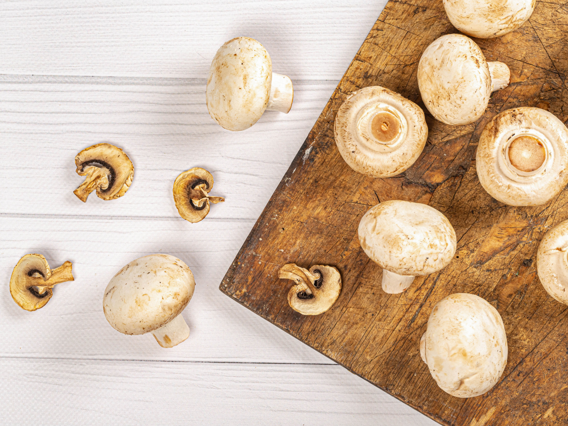 Свежие шампиньоны на разделочной доске