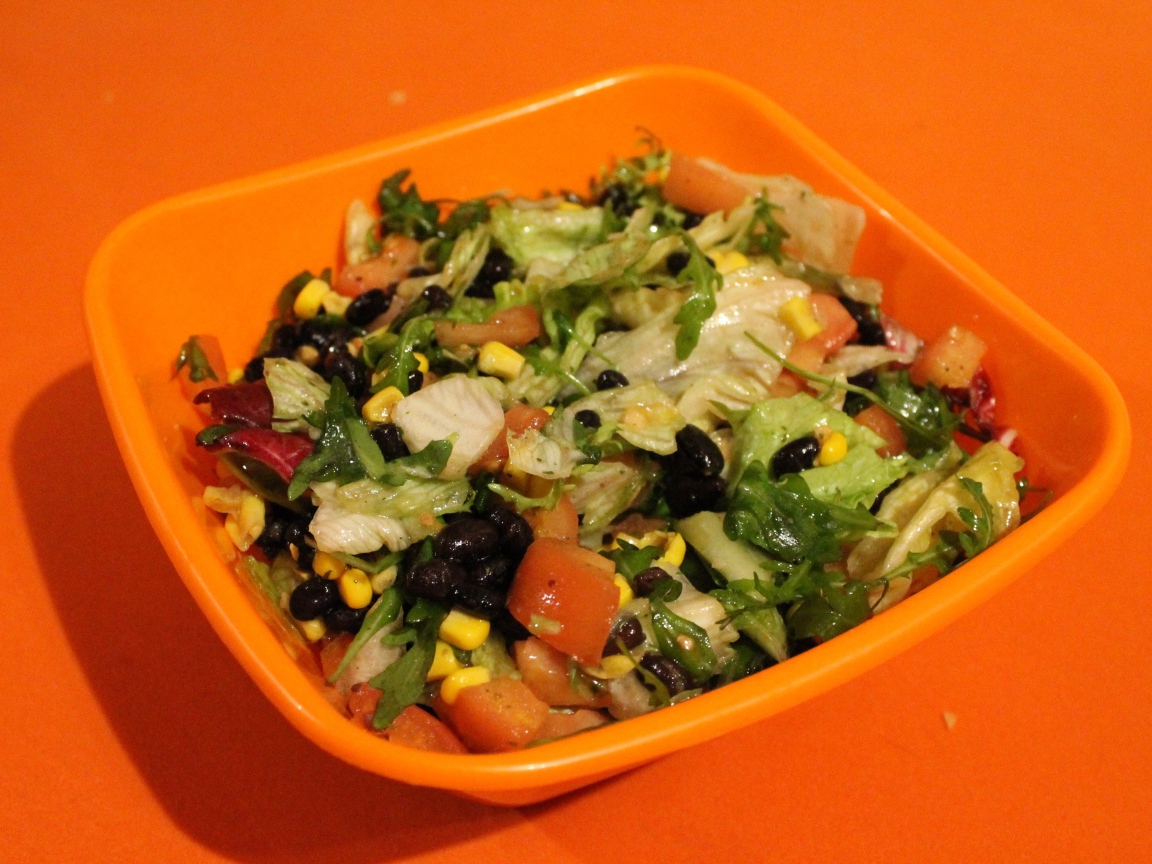 Салат из свежих овощей на оранжевом фоне