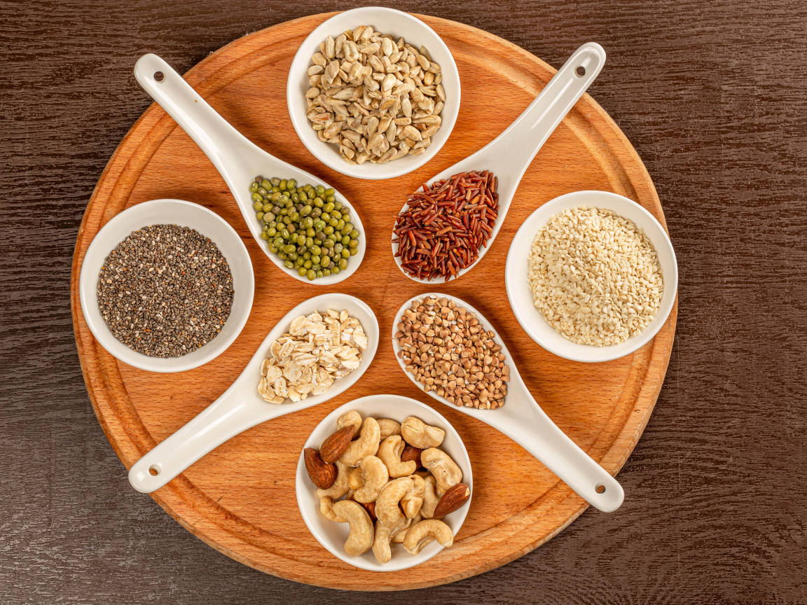 Зерна и орехи на доске на столе 