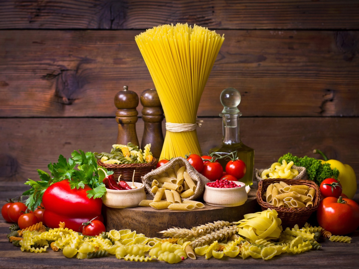 Много макаронных изделий на столе с овощами 