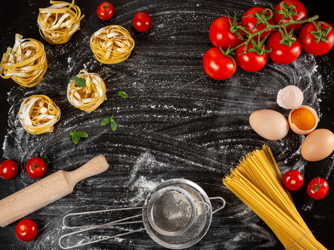 Паста с помидорами и яйцами на черном столе 