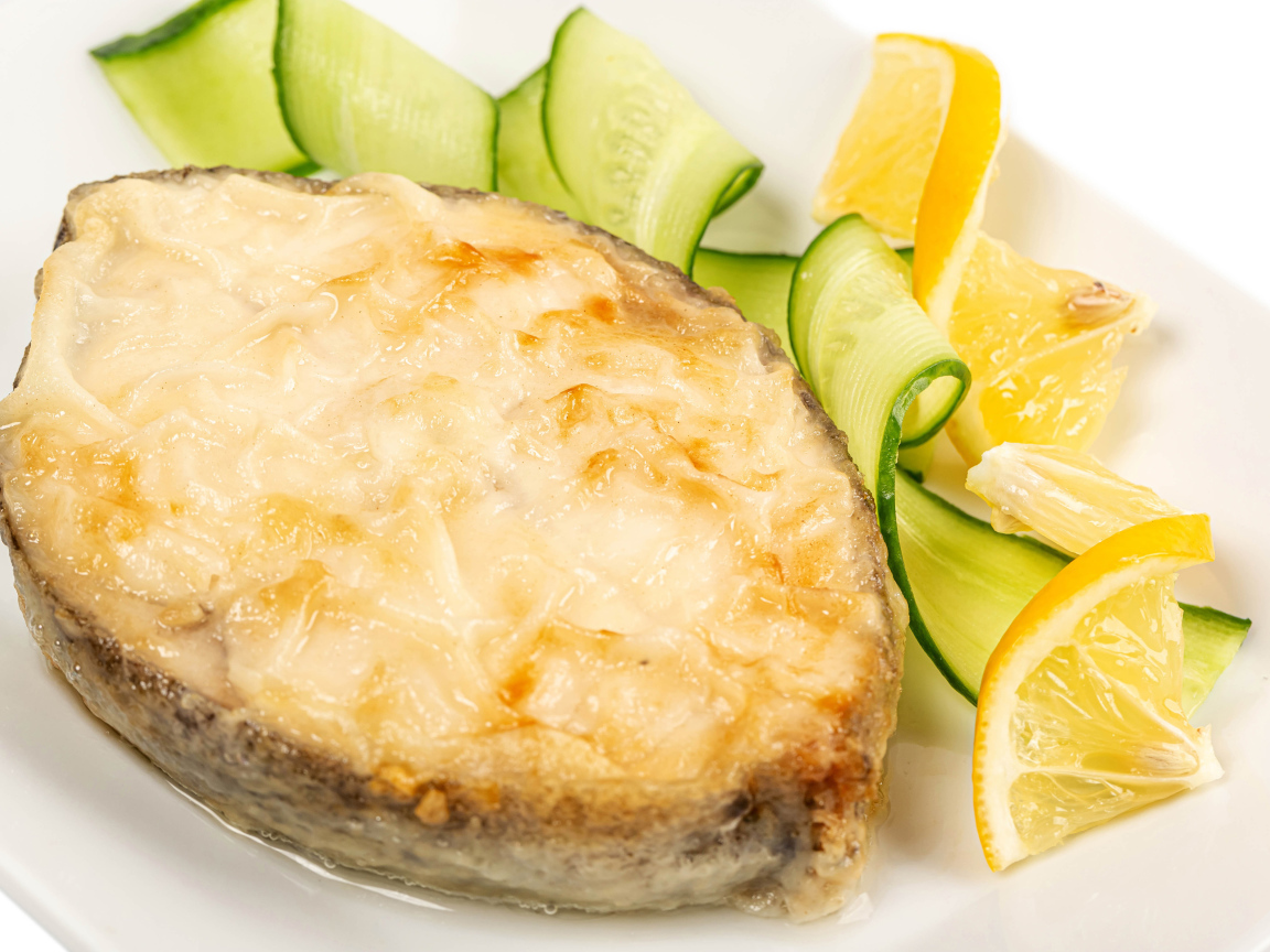 Картофель с сыром на тарелке с огурцами и лимоном 