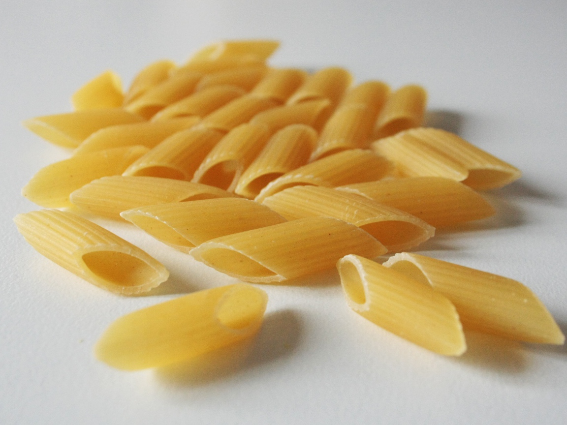 Сырые желтые макароны на сером фоне