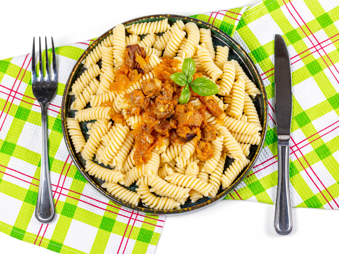 Макароны спираль с мясом на тарелке