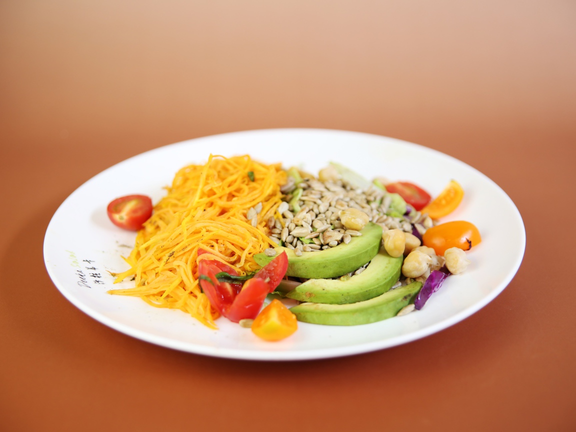 Овощи в белой тарелке на оранжевом фоне 