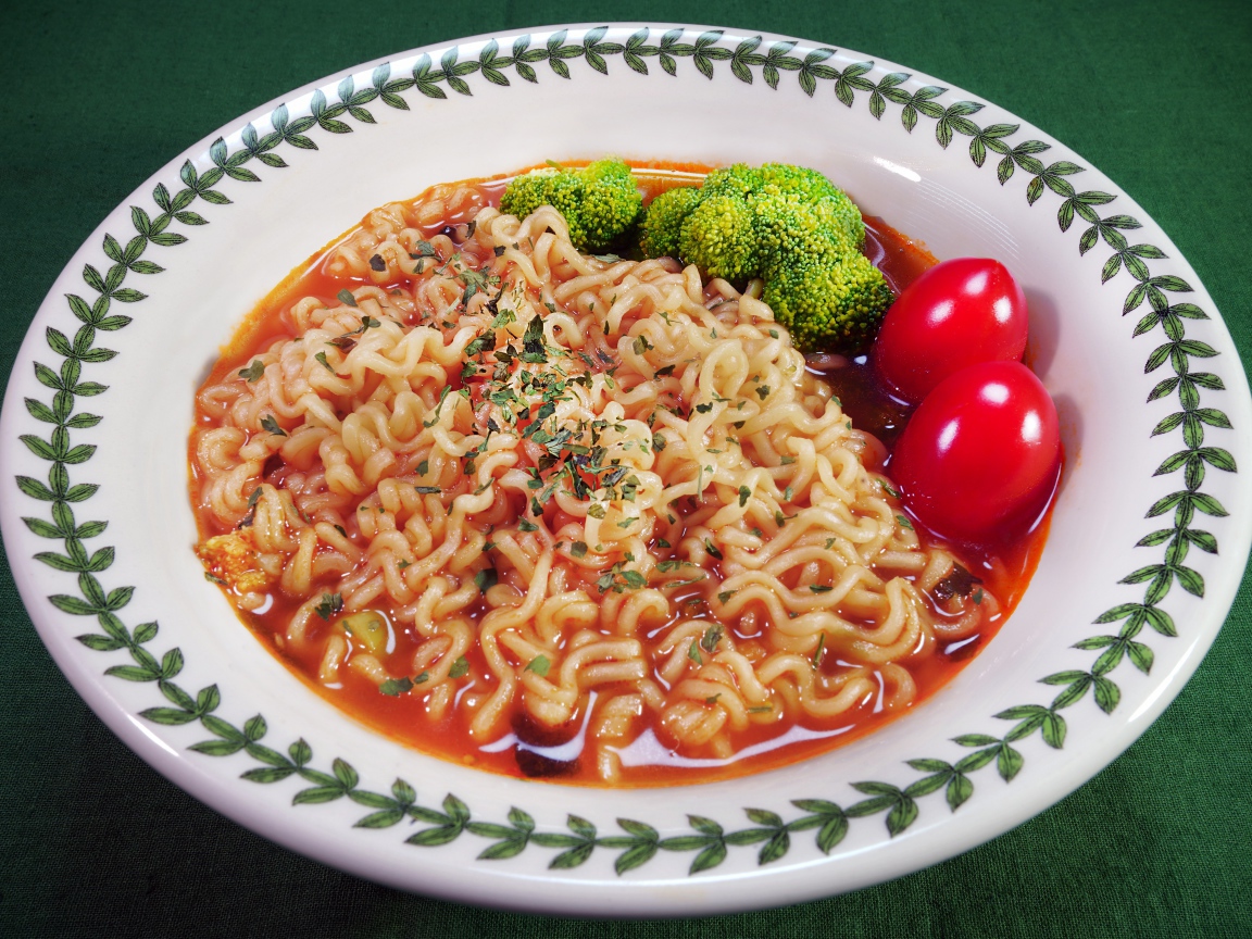 Вермишель с соусом в тарелке с помидорами