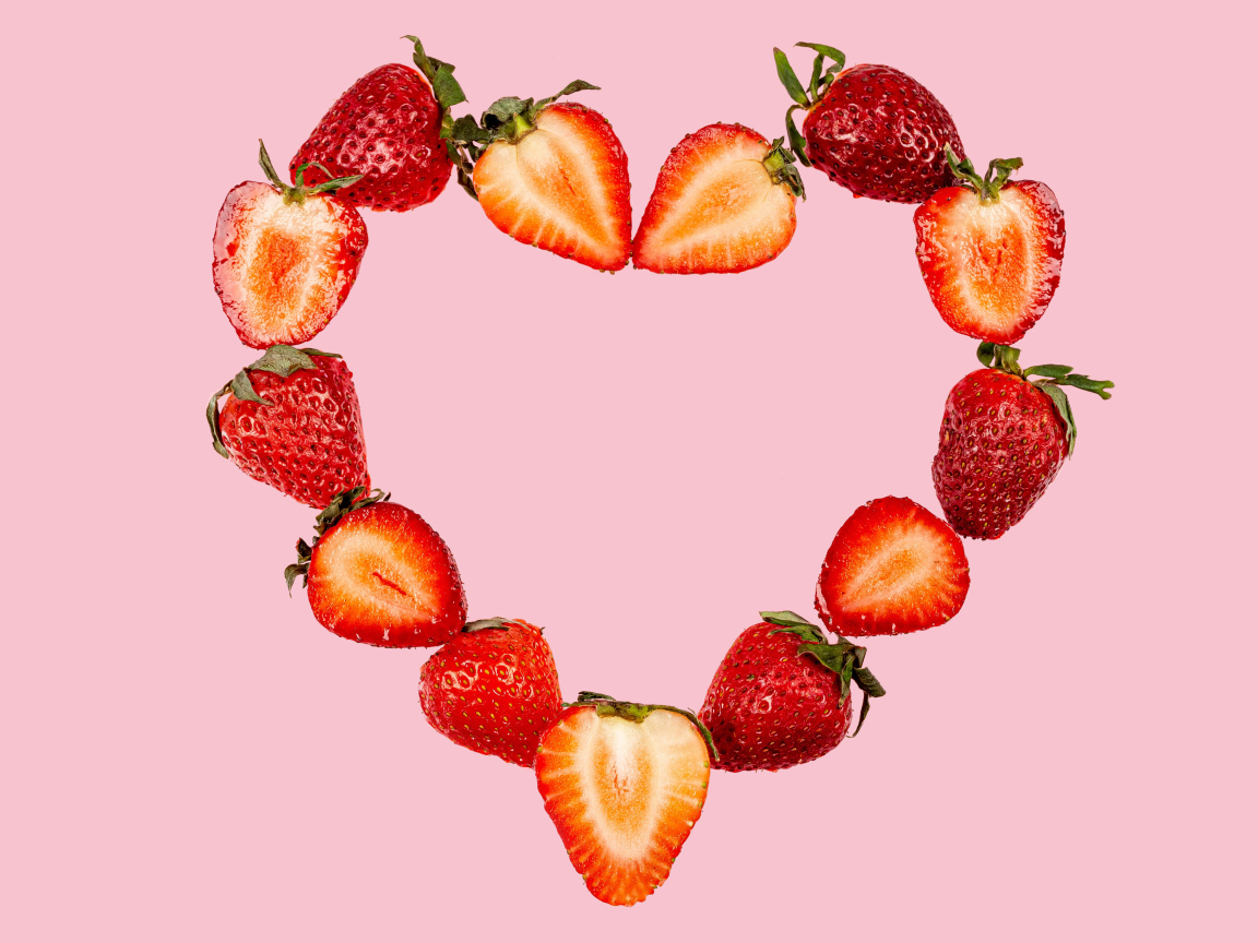 Сердце из клубники на розовом фоне 