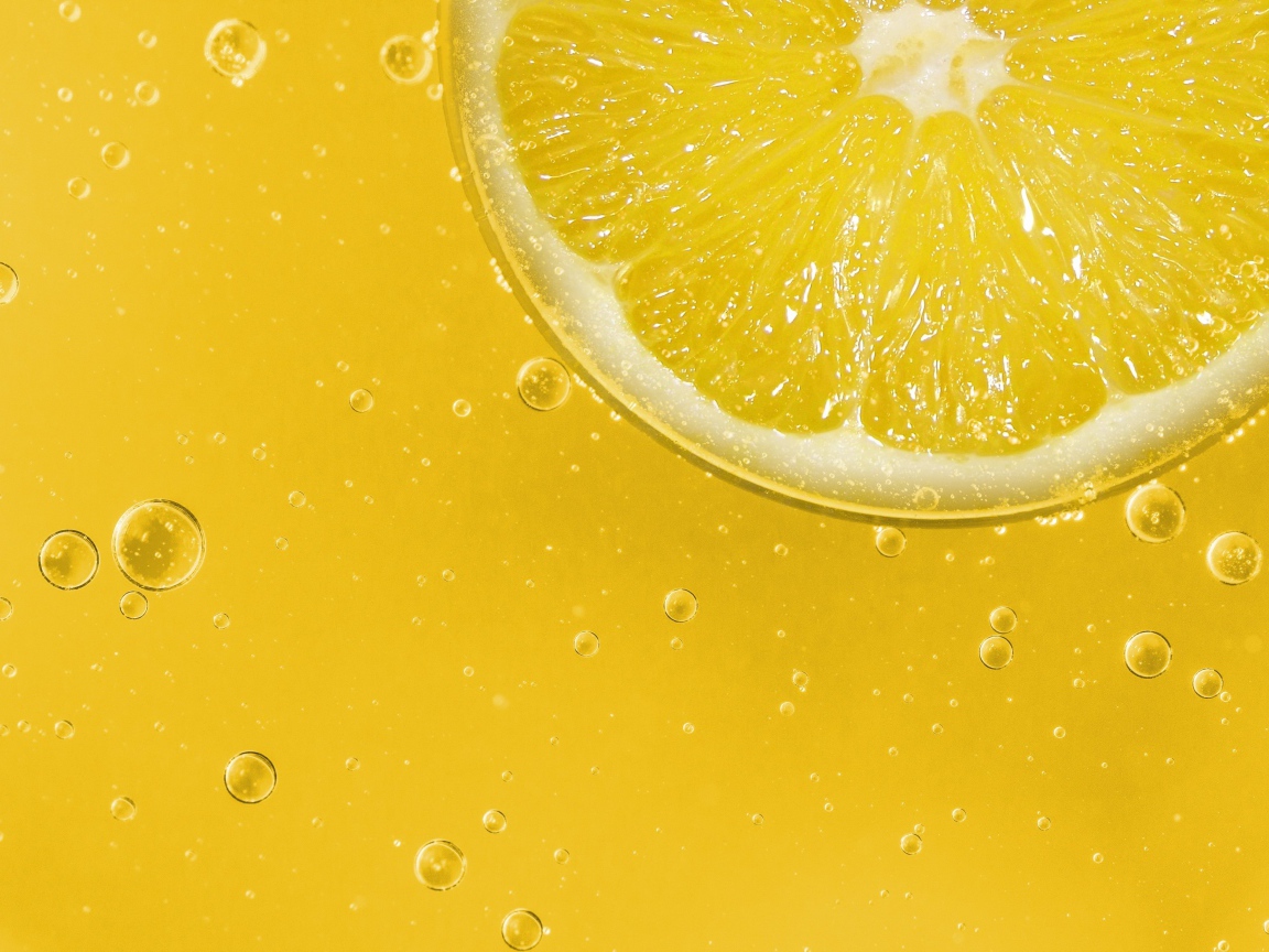 Лимон на желтом фоне с каплями воды