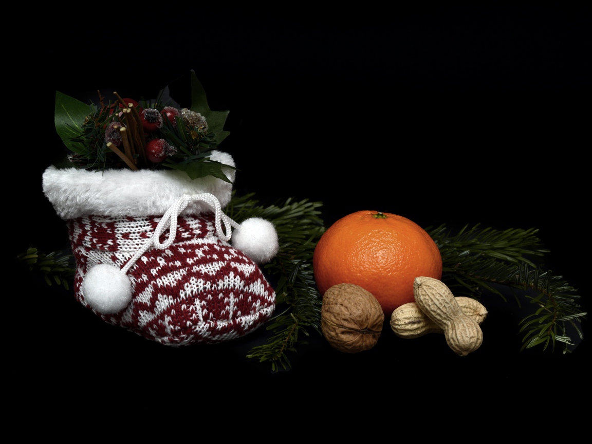 Мандарин с орехами и украшениями на черном фоне 