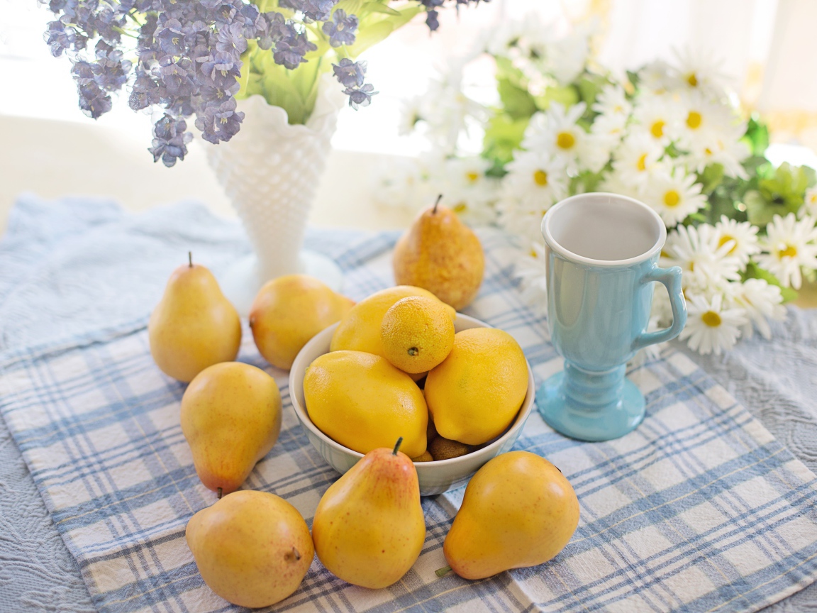 Спелые желтые груши на столе с цветами 