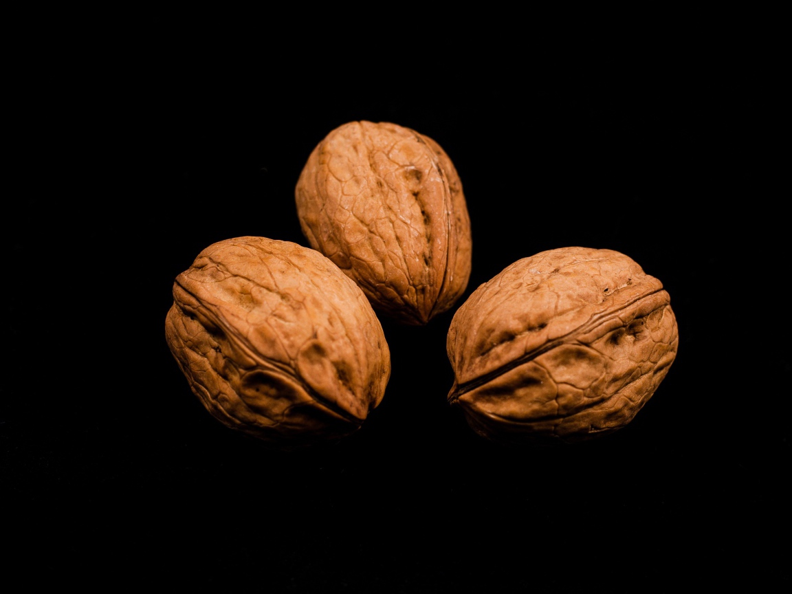 Три грецких ореха на черном фоне 