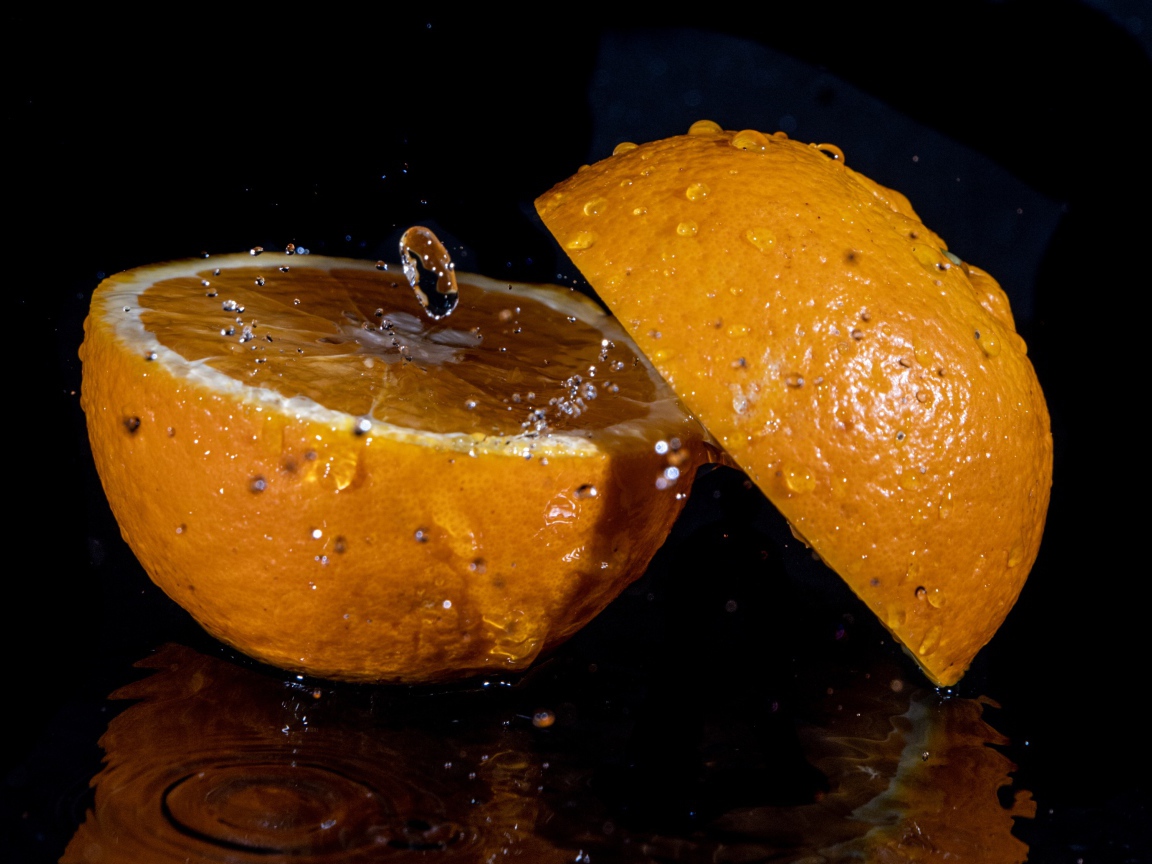 Две половины апельсина на черном фоне 