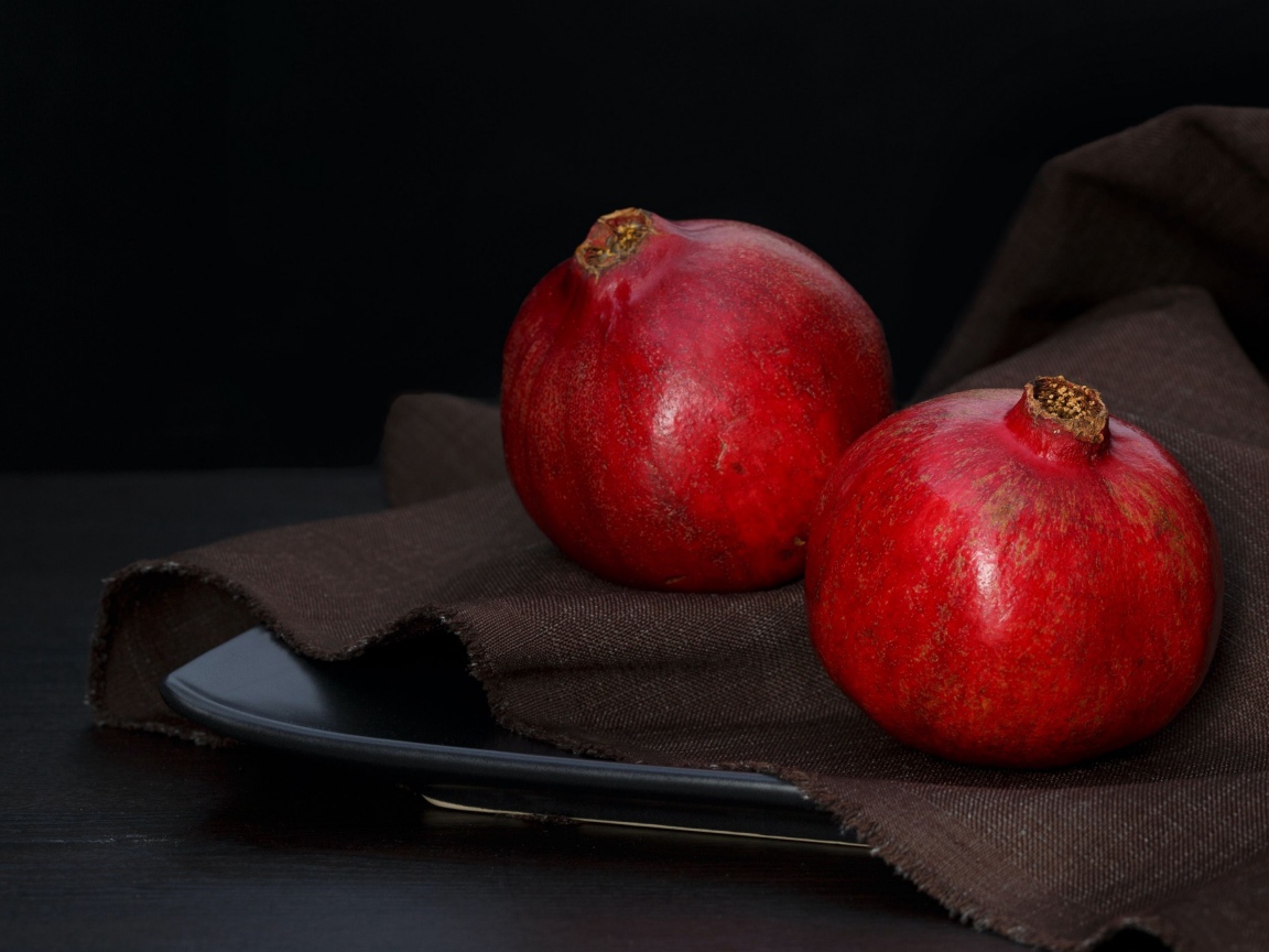 Два красных граната на столе