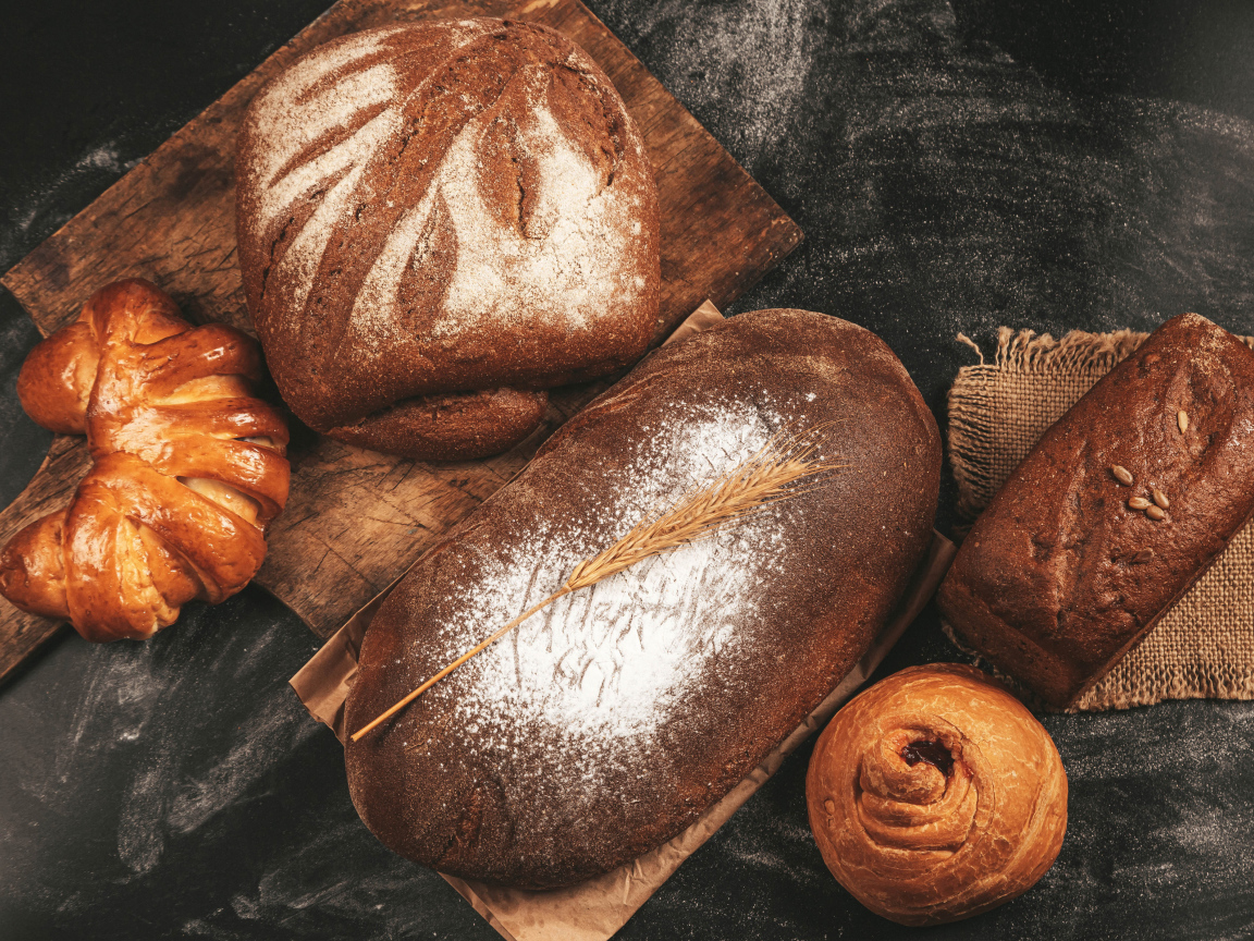 Свежий хлеб и булочки на разделочной доске